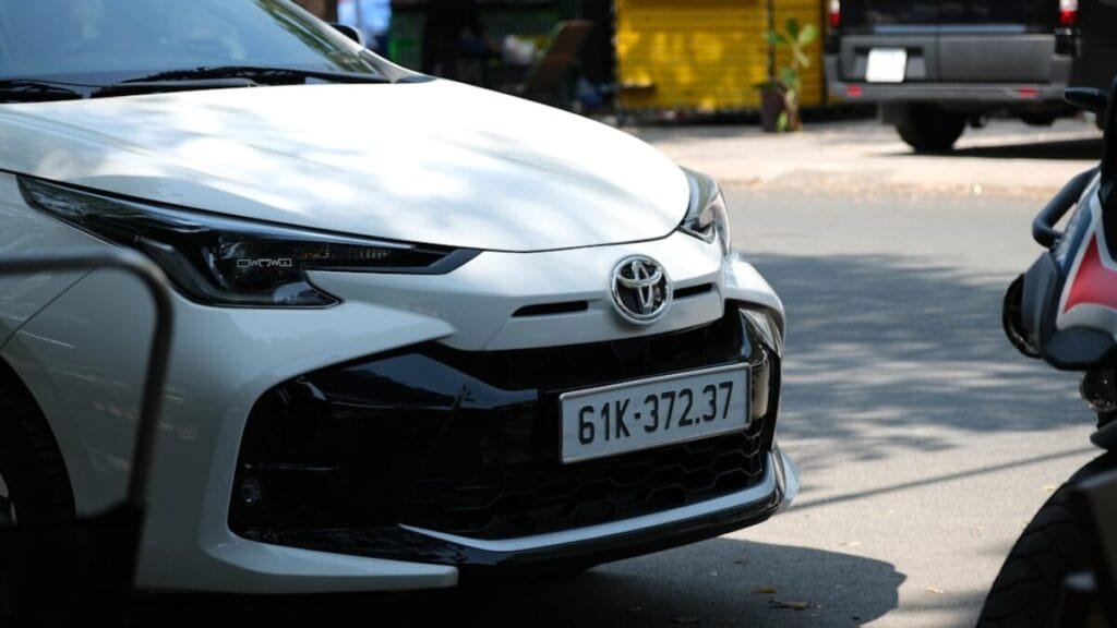 A white car parked next to a motorcycle on a street